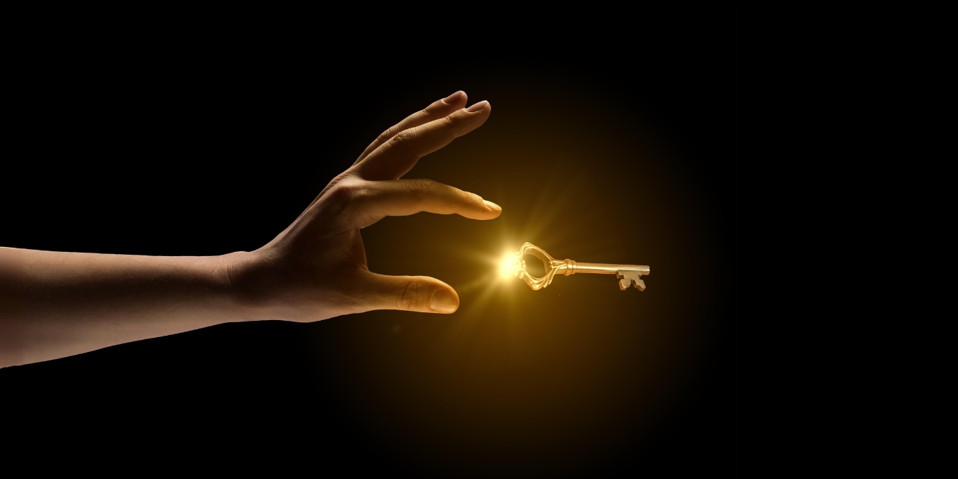 hand reaching for a golden shining key