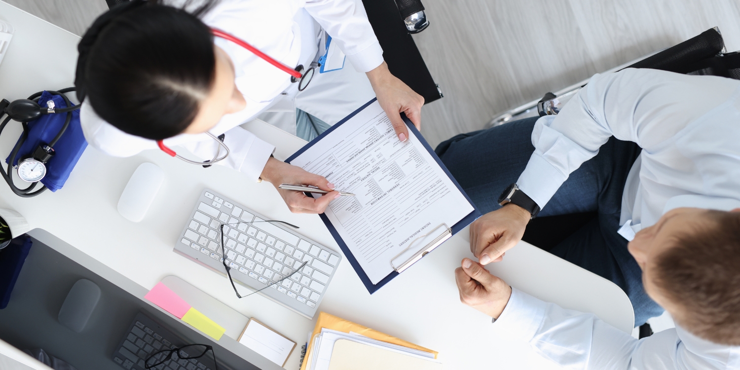top down image of 2 doctors discussing medical paperwork