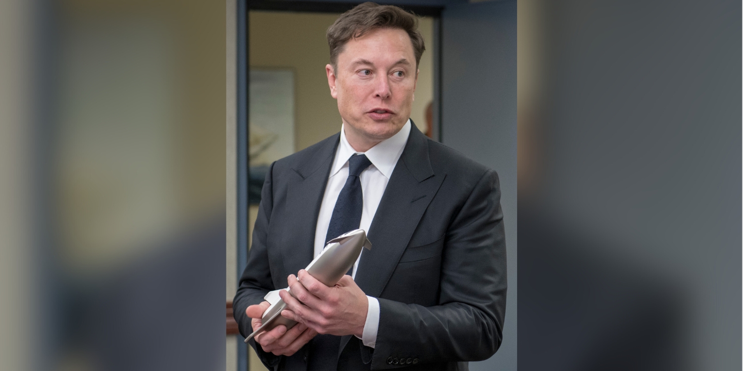 Elon Musk holding spaceship prototype